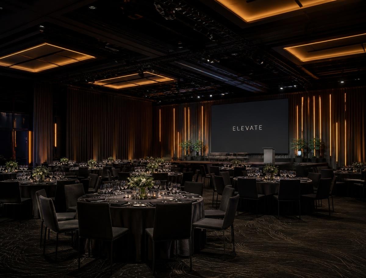 Dark modern ballroom set for a corporate gala dinner with warm architectural lighting